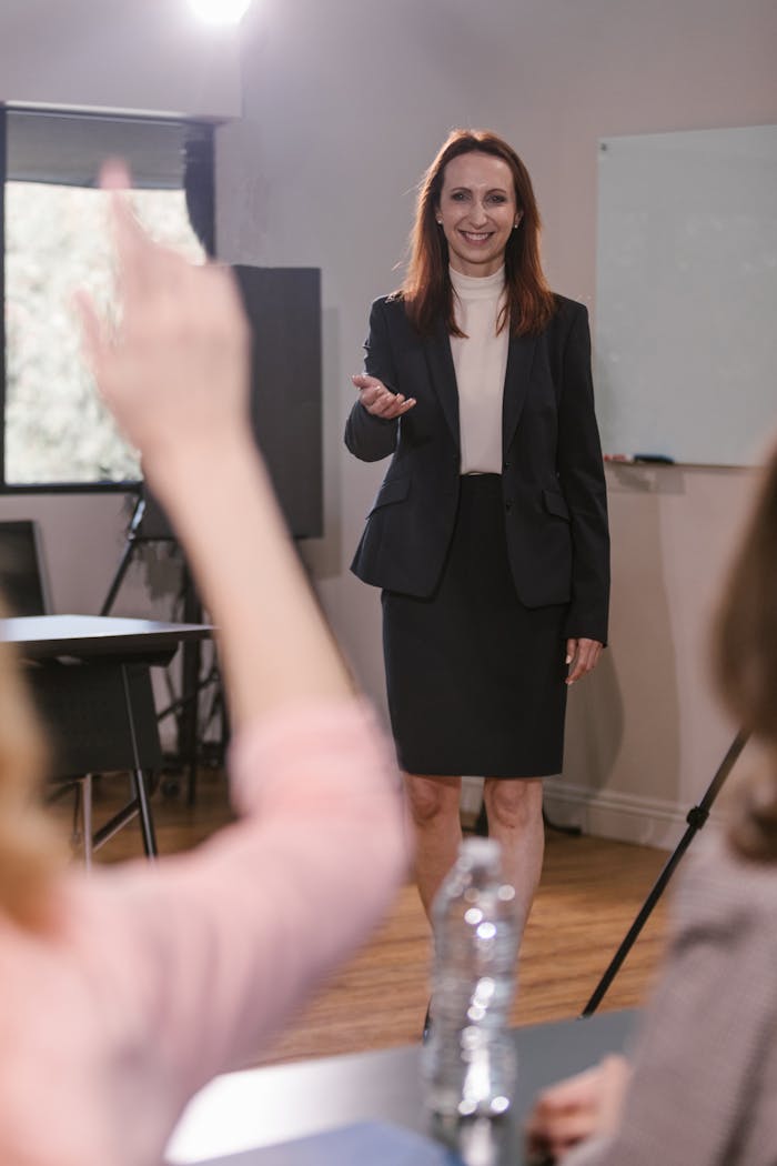 Confident businesswoman speaking to a team during a meeting indoors.
